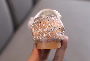 Macro view of glittery rhinestones and pearls on the heel of pink girls dance shoe