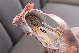 Vue détaillée d'une chaussure de princesse rose pour fille avec nœud et strass