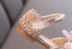 Detailed macro view of pink girl's princess shoe featuring sparkling sequins and elegant pearls