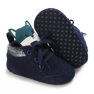 Primer plano de zapatos de bebé en pana azul marino con lengüeta de zorro adorable