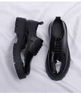 Vista detallada de zapatos de charol negro para hombre con suela de plataforma
