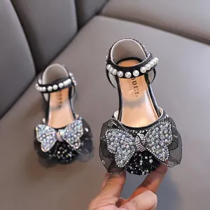 Elegant black princess leather shoes for girls featuring rhinestone bow and pearl ankle strap