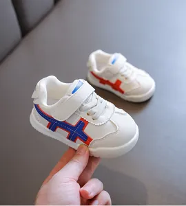 Weiße Baby Lauflernschuhe mit weicher Sohle und dekorativen roten und blauen Streifen