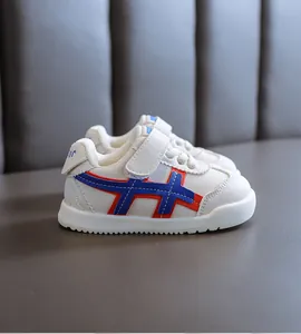 Seitenansicht weißer Lauflernschuhe für Babys mit blauen und roten Streifen und Klettverschluss