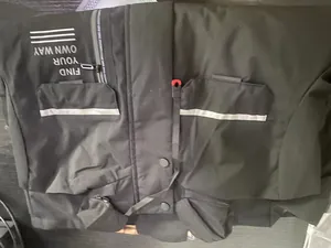 Detail of black men's outdoor hooded parka jacket featuring reflective stripes.