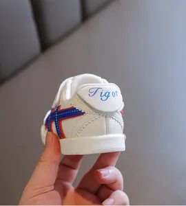 Detailansicht weißer Kleinkinderschuh mit blau-roten Streifen und Tigor-Fersenlogo