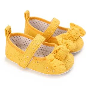 Vue détaillée des chaussures princesse bébé en dentelle jaune avec nœuds pour nourrissons