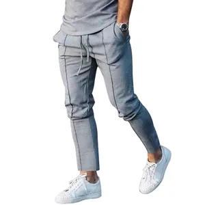 Detailed view of grey slim-fit men's jogger pants with vertical pleated line accents