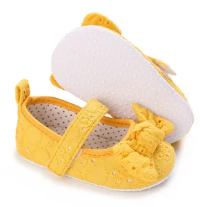 Vue détaillée des chaussures bébé jaunes avec nœud et semelle antidérapante