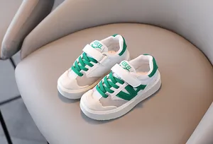 Detalle de zapatillas de malla blanca para niños con cordones verdes y puntera.