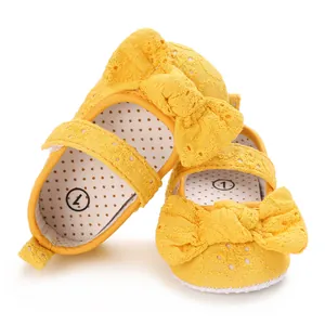 Gros plan détaillé de chaussures de princesse jaunes pour bébé avec dentelle et nœud.
