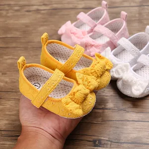 Détail de chaussures de princesse jaune pour bébé avec nœud en dentelle
