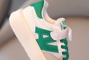 Primer plano de zapatillas de malla transpirable blancas y verdes para niños con velcro