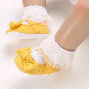 Détail de chaussures de princesse jaunes pour bébé avec dentelle délicate et nœud