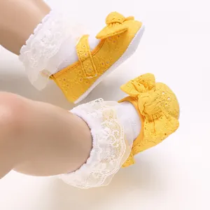 Vue détaillée de chaussures de princesse jaunes pour bébé avec nœuds et dentelle