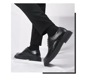 Detail of black men's business dress shoes with embossed pattern and thick sole.