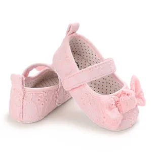 Vue détaillée de chaussures de princesse pour bébé en dentelle rose avec un nœud