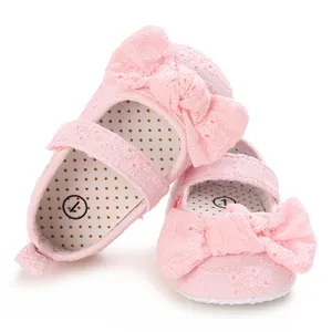 Vue détaillée des chaussures de princesse bébé en dentelle rose avec nœud