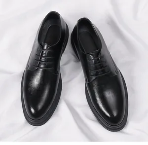 A detailed top view of classic black men's leather business dress shoes on white fabric