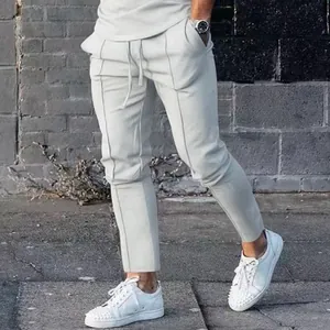 Close-up detail of white men's slim-fit joggers featuring stylish front seams and drawstring