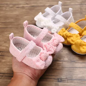 Vue détaillée de chaussures de princesse roses pour bébé avec un grand nœud brodé élégant.