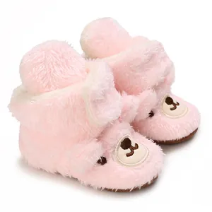 Detailaufnahme von süßen rosa flauschigen Babyschuhen mit Bärengesicht-Stickerei