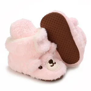 Detailansicht von rosa Plüsch-Babyschuhen mit Bärengesicht und rutschfester Sohle