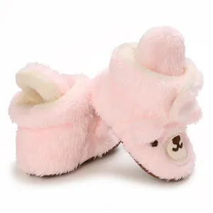 Nahaufnahme von rosa flauschigen Baby-Boots mit süßem gesticktem Bärengesicht