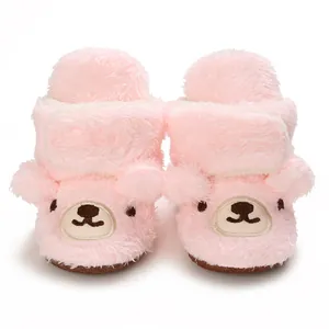Detaillierte Nahaufnahme von rosa Plüsch-Babyschuhen mit einem süßen Bärengesicht
