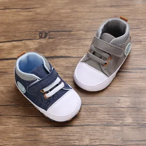 Detailoverzicht van de marineblauwe en grijze baby wandelschoenen op een houten vloer