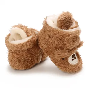 Detailaufnahme brauner Plüsch-Babyschuhe mit Bärengesicht und weichem Fleecefutter