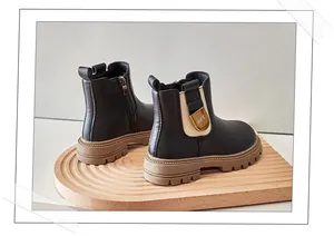 Detailed side view of black children's Martin boots with thick brown lug soles.