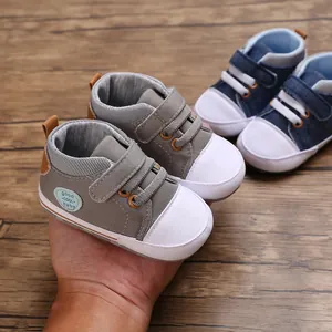 Dichtbij van grijze en blauwe baby canvas loopschoentjes met zachte zolen