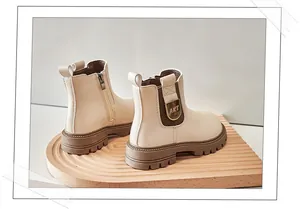 Close-up detail of stylish cream children's Martin boots with thick soles and side zippers