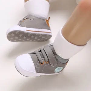 Gedetailleerd overzicht van grijze canvas babyschoentjes met zachte sterrenpatroonzool.