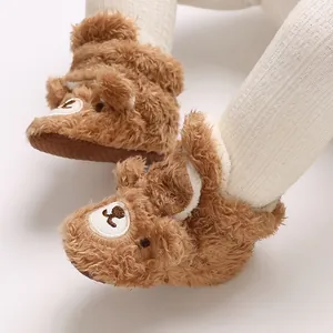 Nahaufnahme von braunen Plüsch-Babypantoffeln in Bärenform mit einer weichen, flaumigen Textur.