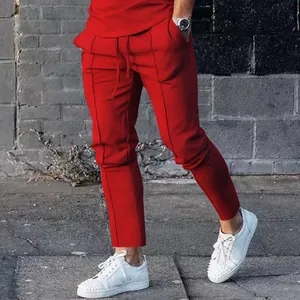 Side view of red slim-fit men's high street sport pants worn with white sneakers