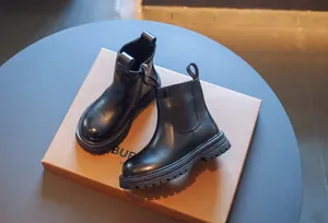 Vue détaillée de bottines noires pour enfants avec fermeture éclair et languette