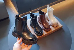 Gros plan de bottines Chelsea pour enfants style britannique en noir, marron et blanc