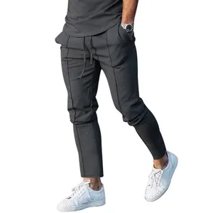 Close-up of dark grey slim-fit men's casual joggers featuring unique vertical seam accents