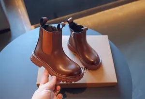 Gros plan de bottines Chelsea marron pour enfants avec fermeture éclair latérale et semelle