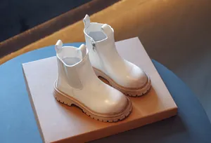 Gros plan de bottines Martin blanches pour enfants avec fermeture éclair latérale pratique