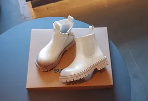 Gros plan de bottines blanches pour enfants avec fermeture éclair et semelle épaisse