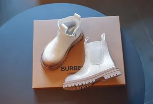 Gros plan de bottines Chelsea blanches pour enfants avec une fermeture éclair latérale