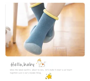 Close-up of blue ribbed knit baby walking sock shoes with flexible non-slip soft soles