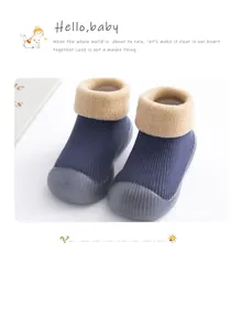 Detail view of thick warm baby sock shoes with blue knit and lamb wool cuffs.