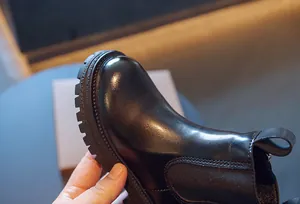 Gros plan sur les bottines Chelsea noires pour enfants montrant la texture du cuir