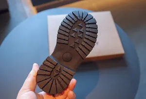 Vue rapprochée de la semelle extérieure en caoutchouc durable des bottes Martin enfant.