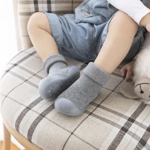 Close-up of grey knit baby walker shoes with soft non-slip soles on a toddler feet
