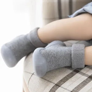 Close-up of grey knit baby sock shoes with non-slip soft rubber soles for winter warmth